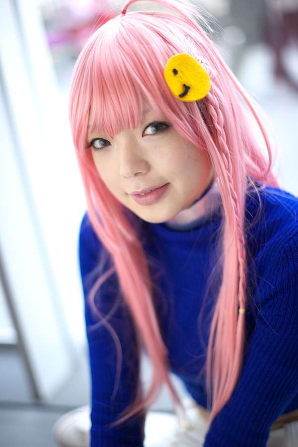 namada, nono (top wo nerae 2!), top wo nerae! (series), top wo nerae 2!, photo (medium), 1girl, asian, blue eyes, blue sweater, blurry, braid, breasts, color contacts, cosplay, depth of field, female focus, indoors, long hair, looking at viewer, makeup, mascara, parted lips, pink hair, side braid, sidelocks, small breasts, solo, sweater