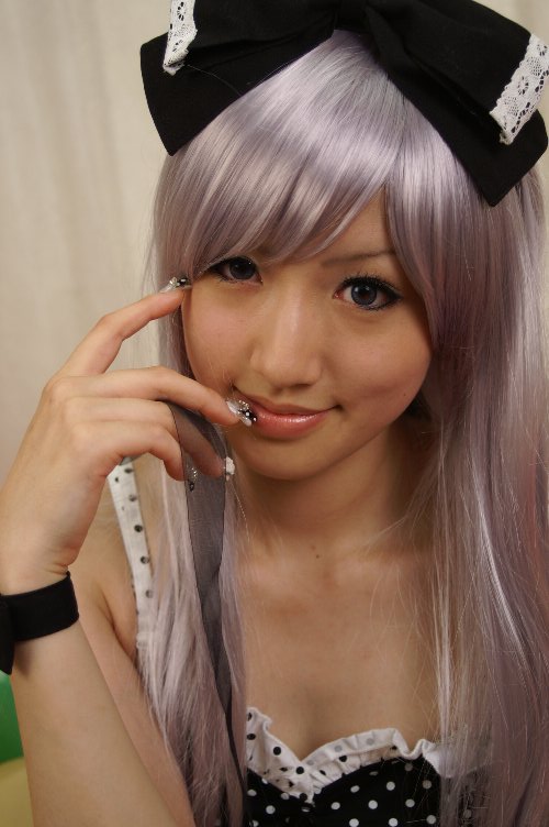 saya (cosplayer), silver hair, photo (medium), 1girl, asian, balloon, bow, cosplay, couch, dress, female focus, hair bow, nail polish, polka dot, polka dot dress, red upholstery, ribbon, smile
