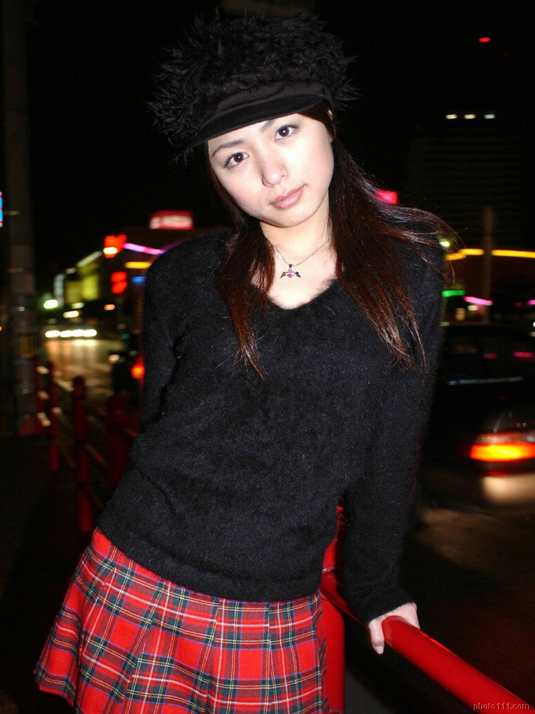 kawamura yuki, photo (medium), tagme, 1girl, asian, black sweater, breasts, city, female focus, looking at viewer, medium breasts, miniskirt, night, outdoors, plaid clothes, plaid skirt, silly hat, skirt, solo, sweater