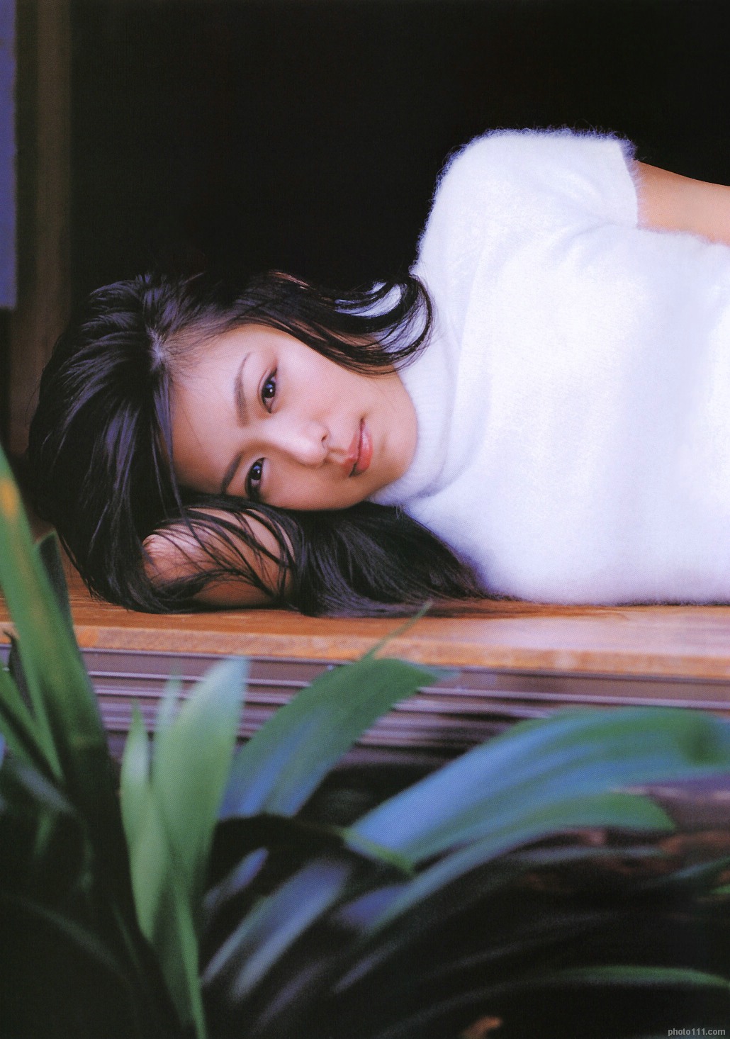 kawamura yuki, highres, photo (medium), tagme, 1girl, asian, female focus, fuzzy sweater, long hair, looking at viewer, lying, on side, outdoors, plant, solo