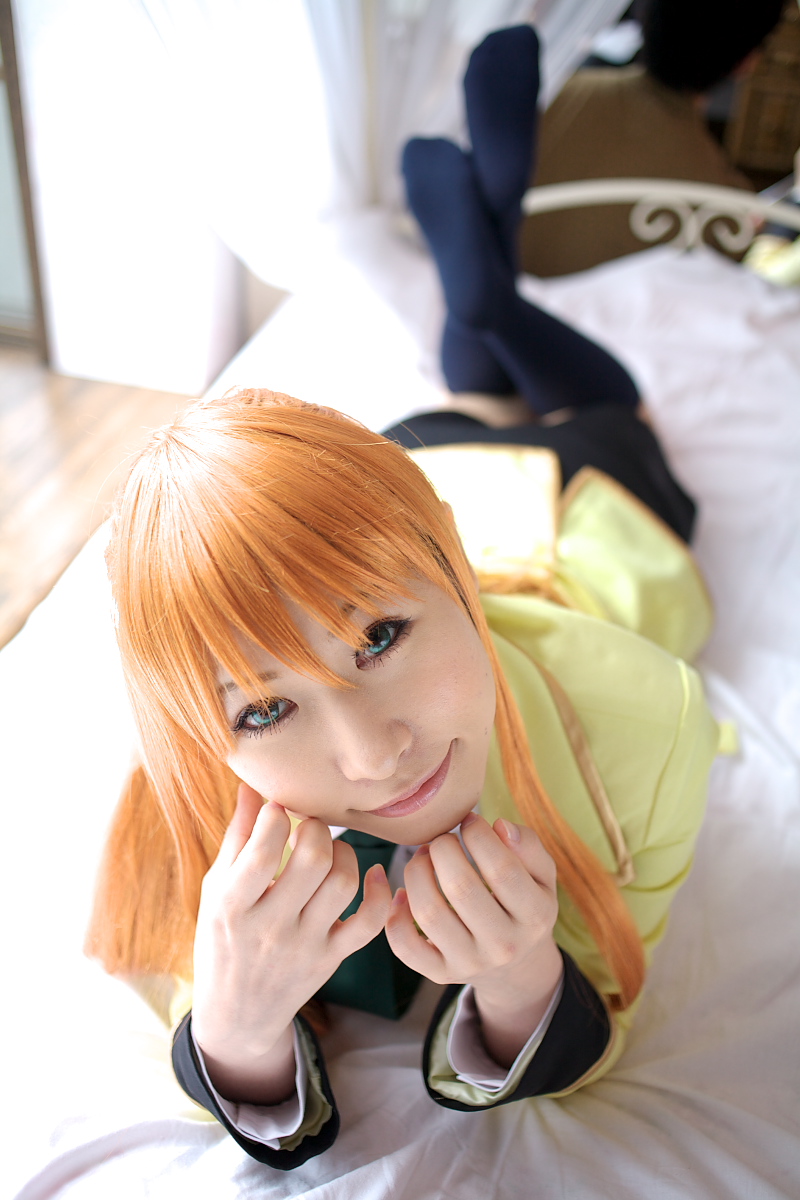 chippi, shirley fenette, code geass, highres, photo (medium), 1girl, asian, bed, bedroom, blazer, blue eyes, color contacts, cosplay, female focus, jacket, kneehighs, long hair, looking at viewer, lying, miniskirt, on stomach, orange hair, school uniform, shirley fenette (cosplay), skirt, socks, solo