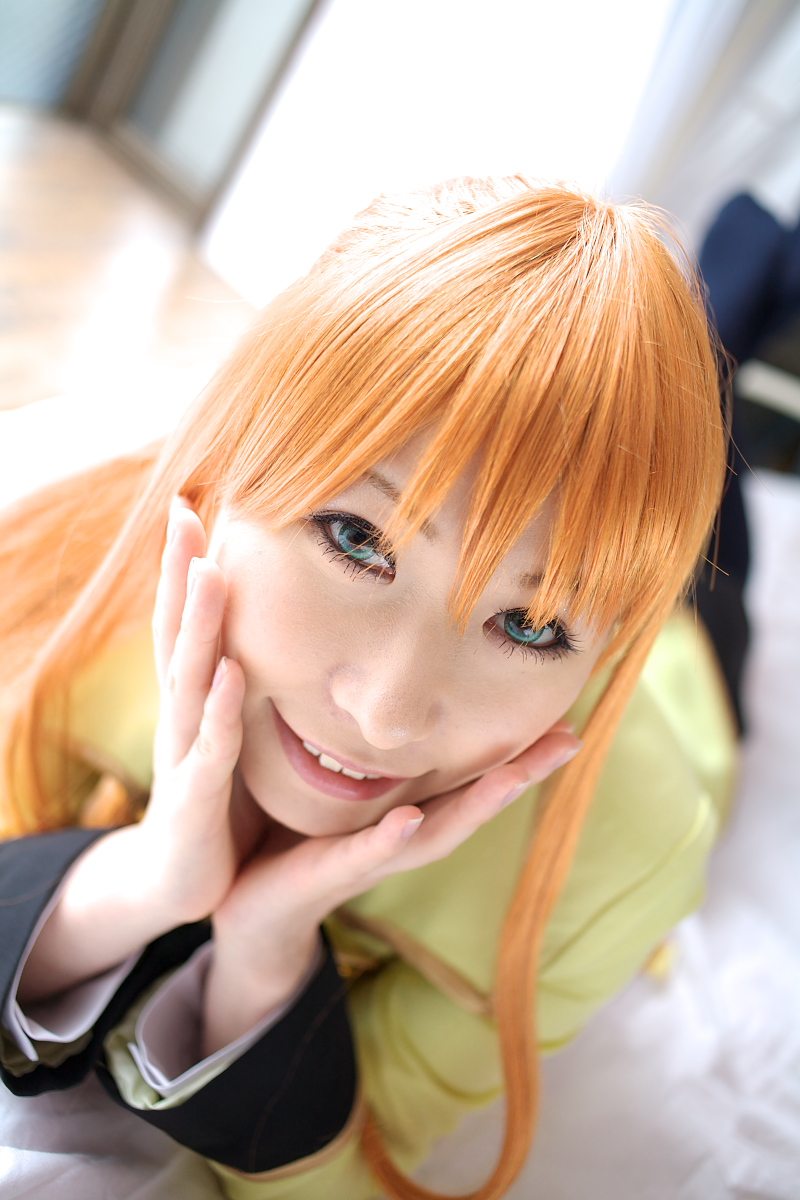 chippi, shirley fenette, code geass, highres, photo (medium), 1girl, asian, bed, bedroom, blazer, blue eyes, color contacts, cosplay, dutch angle, female focus, indoors, jacket, kneehighs, long hair, looking at viewer, lying, miniskirt, on stomach, orange hair, school uniform, shirley fenette (cosplay), skirt, smile, socks, solo