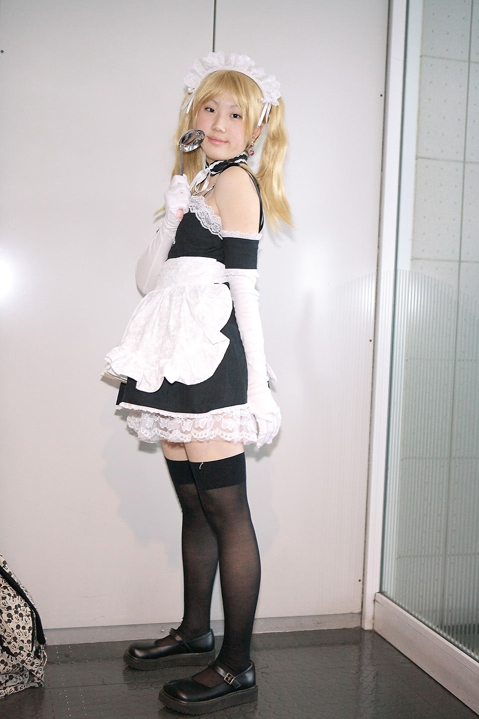 hime (cosplayer), sawatari izumi, kore ga watashi no goshujin-sama, highres, photo (medium), 1girl, apron, asian, bare shoulders, black shoes, black thighhighs, blonde hair, cosplay, detached collar, earrings, elbow gloves, female focus, full body, gloves, indoors, japanese (nationality), jewelry, ladle, looking at viewer, maid, maid apron, maid headdress, mary janes, nakabayashi yoshitaka's maid uniform, sawatari izumi (cosplay), shoes, solo, standing, thighhighs, twintails, white gloves, zettai ryouiki