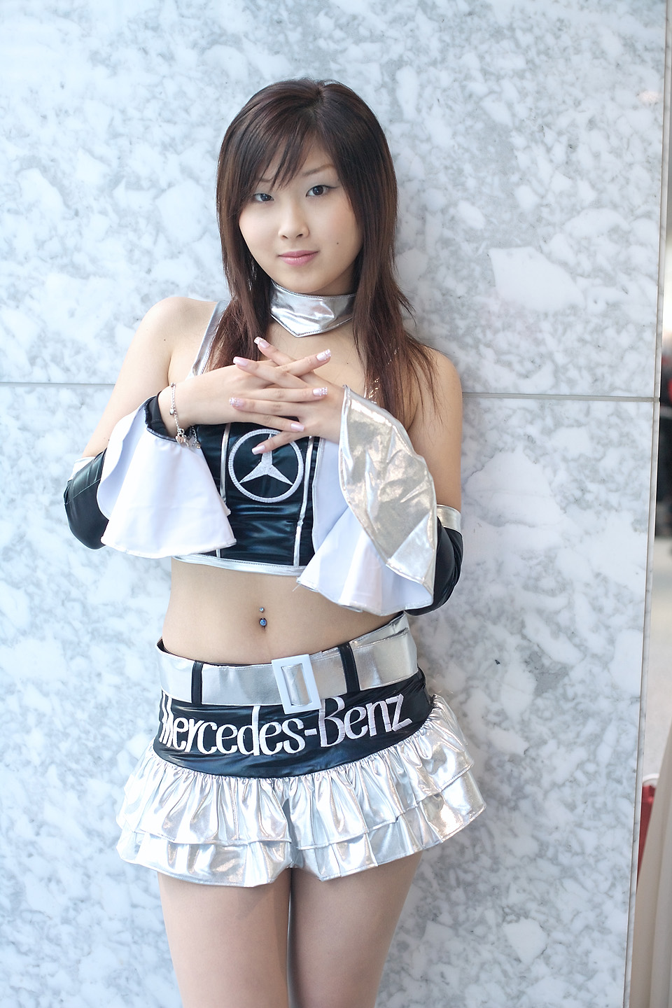 natsu suzune, highres, photo (medium), 1girl, asian, bare shoulders, belt, bracelet, brown eyes, brown hair, campaign girl, cosplay, female focus, fingernails, halterneck, jewelry, light smile, looking at viewer, midriff, miniskirt, nail polish, own hands together, race queen, shirt, skirt, sleeveless, sleeveless shirt, smile, solo, swept bangs, vinyl