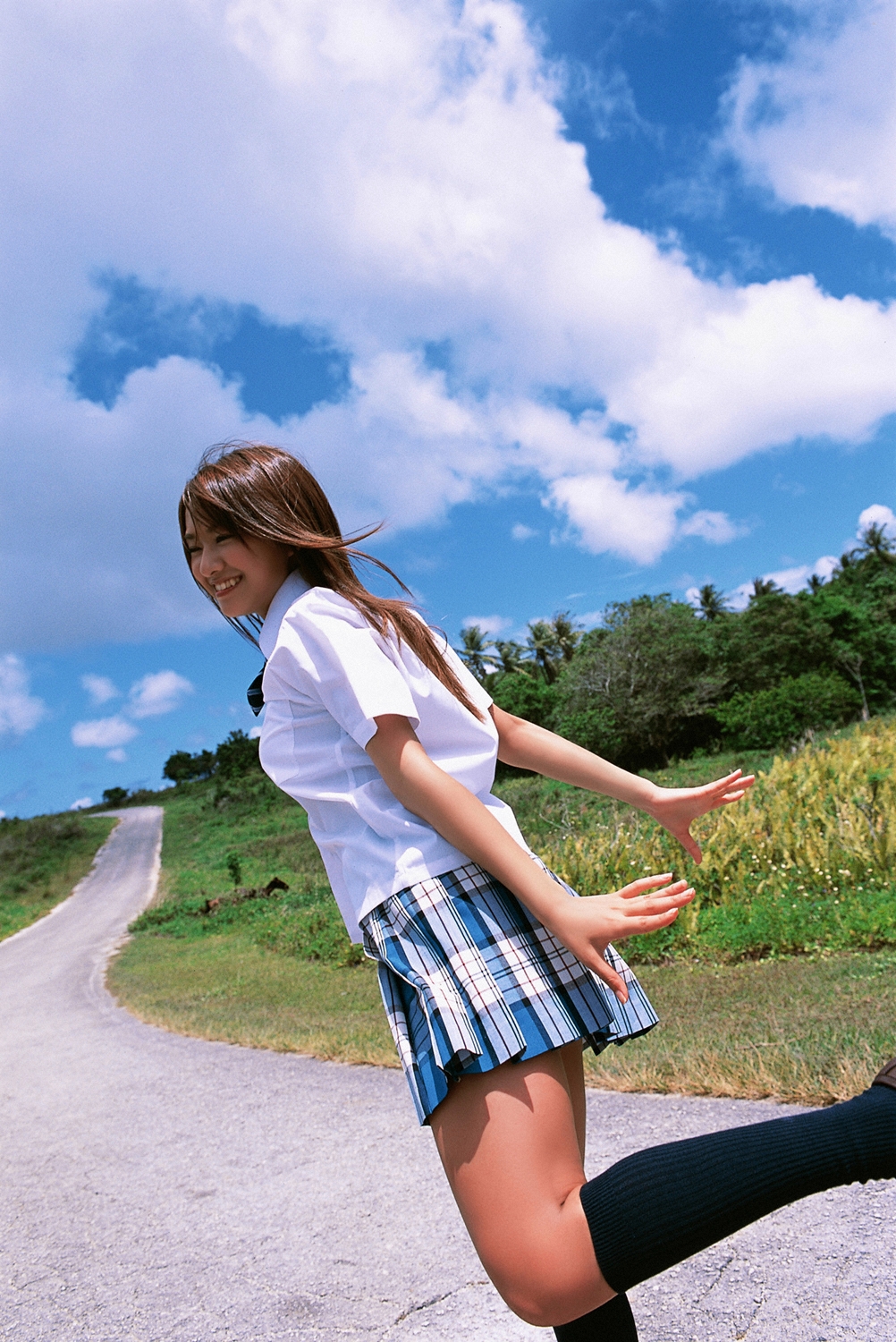 kamata natsumi, highres, photo (medium), 1girl, asian, blouse, blurry, brown hair, cloud, cosplay, depth of field, dutch angle, female focus, japanese (nationality), kneehighs, long hair, miniskirt, outdoors, pleated skirt, road, school uniform, shirt, skirt, sky, smile, socks, solo