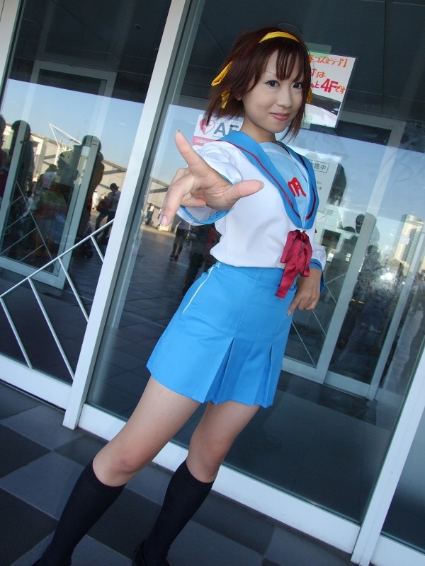 torai aki, suzumiya haruhi, suzumiya haruhi no yuuutsu, photo (medium), 1girl, armband, asian, cosplay, dutch angle, female focus, hair ribbon, kneehighs, looking at viewer, outdoors, ribbon, sailor, school uniform, serafuku, socks, solo, suzumiya haruhi (cosplay)