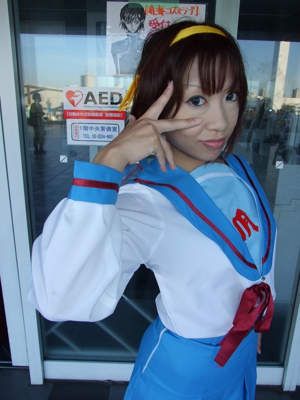 torai aki, suzumiya haruhi, suzumiya haruhi no yuuutsu, photo (medium), 1girl, armband, asian, cosplay, female focus, hair ribbon, looking at viewer, outdoors, ribbon, sailor, school uniform, serafuku, solo, suzumiya haruhi (cosplay)