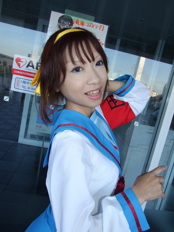 torai aki, suzumiya haruhi, suzumiya haruhi no yuuutsu, photo (medium), 1girl, armband, asian, cosplay, female focus, hair ribbon, looking at viewer, outdoors, ribbon, sailor, school uniform, serafuku, solo, suzumiya haruhi (cosplay)