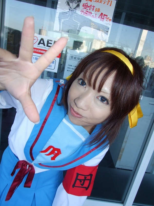 torai aki, suzumiya haruhi, suzumiya haruhi no yuuutsu, photo (medium), 1girl, armband, asian, cosplay, female focus, hair ribbon, looking at viewer, outdoors, ribbon, sailor, school uniform, serafuku, solo, suzumiya haruhi (cosplay)