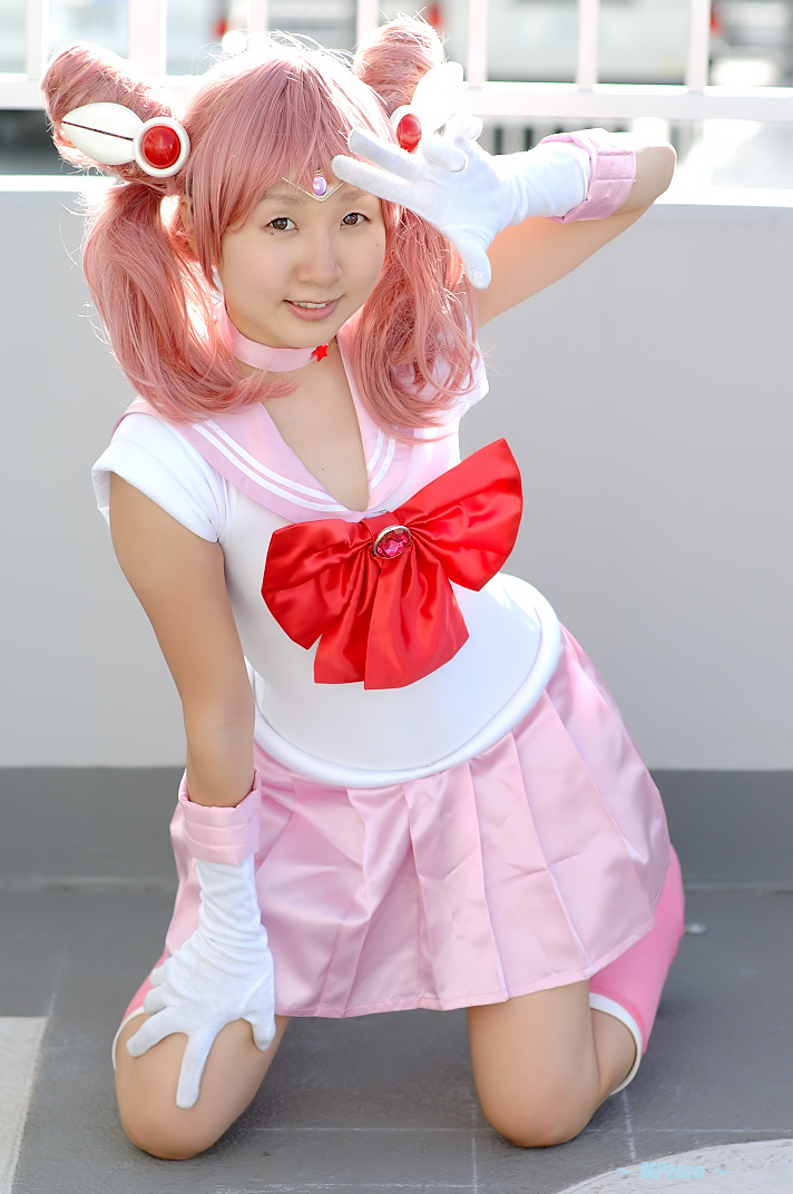 miasa, chibi usa, sailor chibi moon, bishoujo senshi sailor moon, photo (medium), 1girl, asian, boots, brown eyes, cosplay, female focus, gloves, kneeling, looking at viewer, mole, mole under eye, outdoors, pink hair, sailor, sailor chibi moon (cosplay), school uniform, serafuku, solo, twintails, white gloves