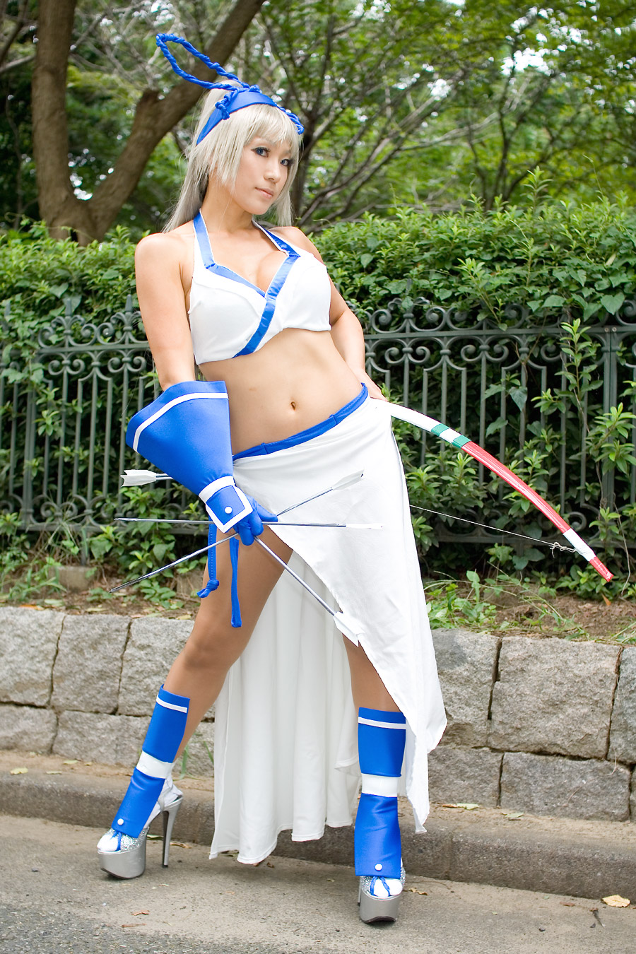 igarashi nao (model), majikina mina, real life, samurai spirits, snk, cosplay photo, highres, photo (medium), 1girl, bow, breasts, cleavage, cosplay, female focus, hair bow, halterneck, high heels, majikina mina (cosplay), midriff, navel, shoes, solo, white hair