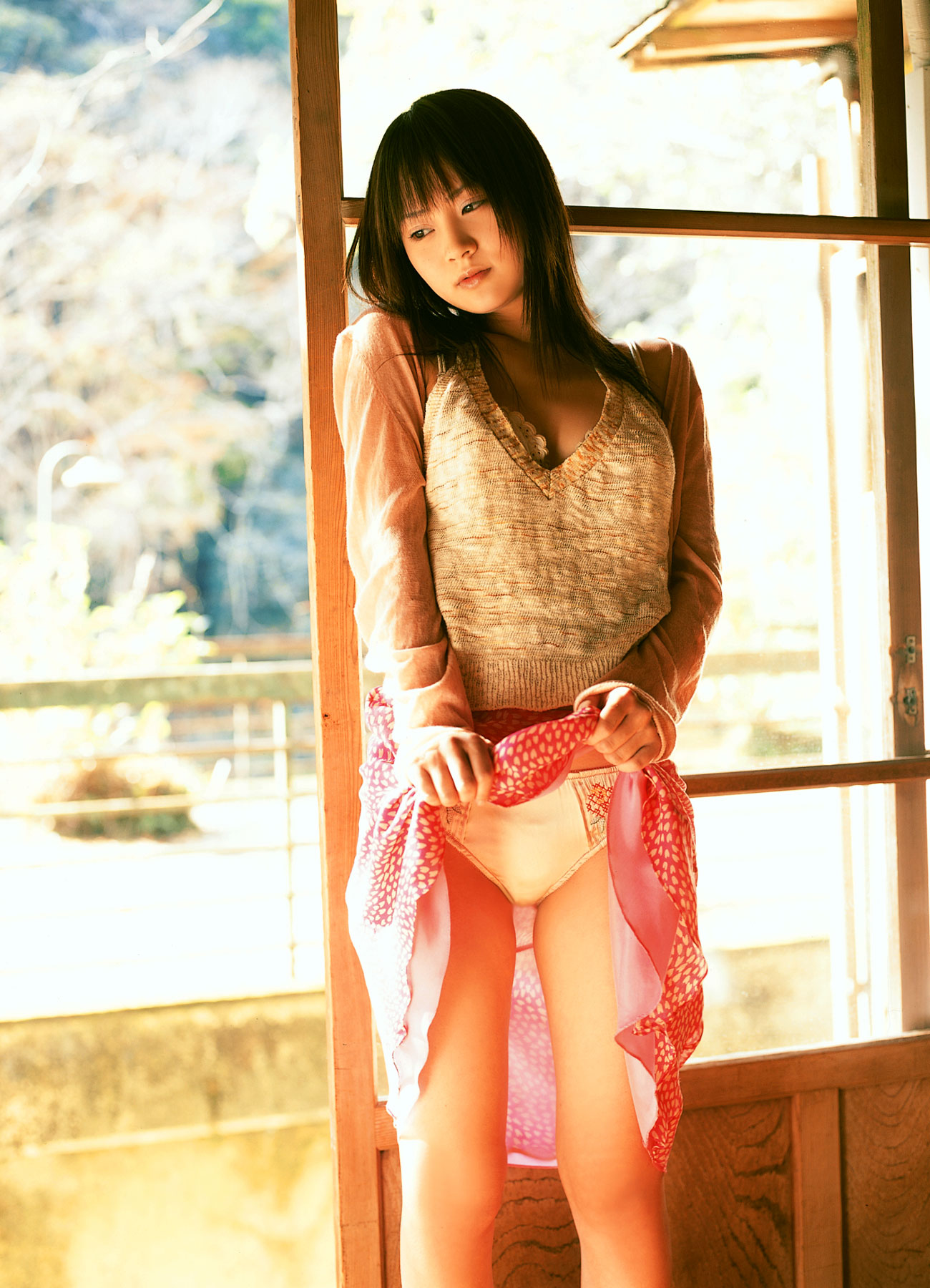 hamada shoko, highres, photo (medium), 1girl, asian, blurry, brown hair, clothes lift, cowboy shot, depth of field, female focus, indoors, long hair, panties, skirt, skirt lift, solo, standing, sweater, underwear