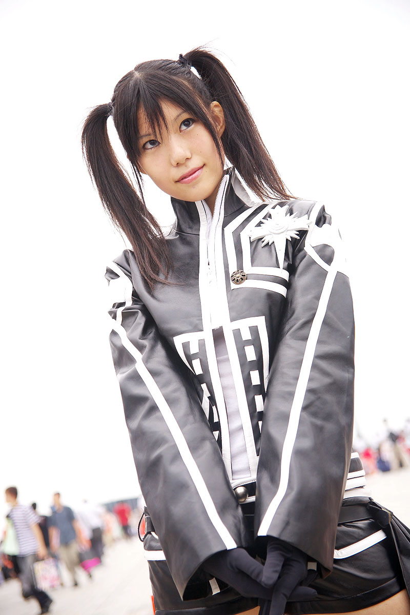 rubia, lenalee lee, d.gray-man, highres, photo (medium), 1girl, 6+boys, black gloves, black hair, blurry, cosplay, depth of field, dutch angle, gloves, lenalee lee (cosplay), multiple boys, outdoors, shorts, solo focus, twintails