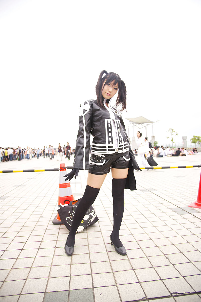 rubia, lenalee lee, d.gray-man, black footwear, black legwear, highres, photo (medium), 2girls, 6+boys, black gloves, black hair, cosplay, dutch angle, gloves, lenalee lee (cosplay), looking at viewer, multiple boys, multiple girls, outdoors, shoes, shorts, solo focus, thighhighs, traffic cone, twintails, zettai ryouiki