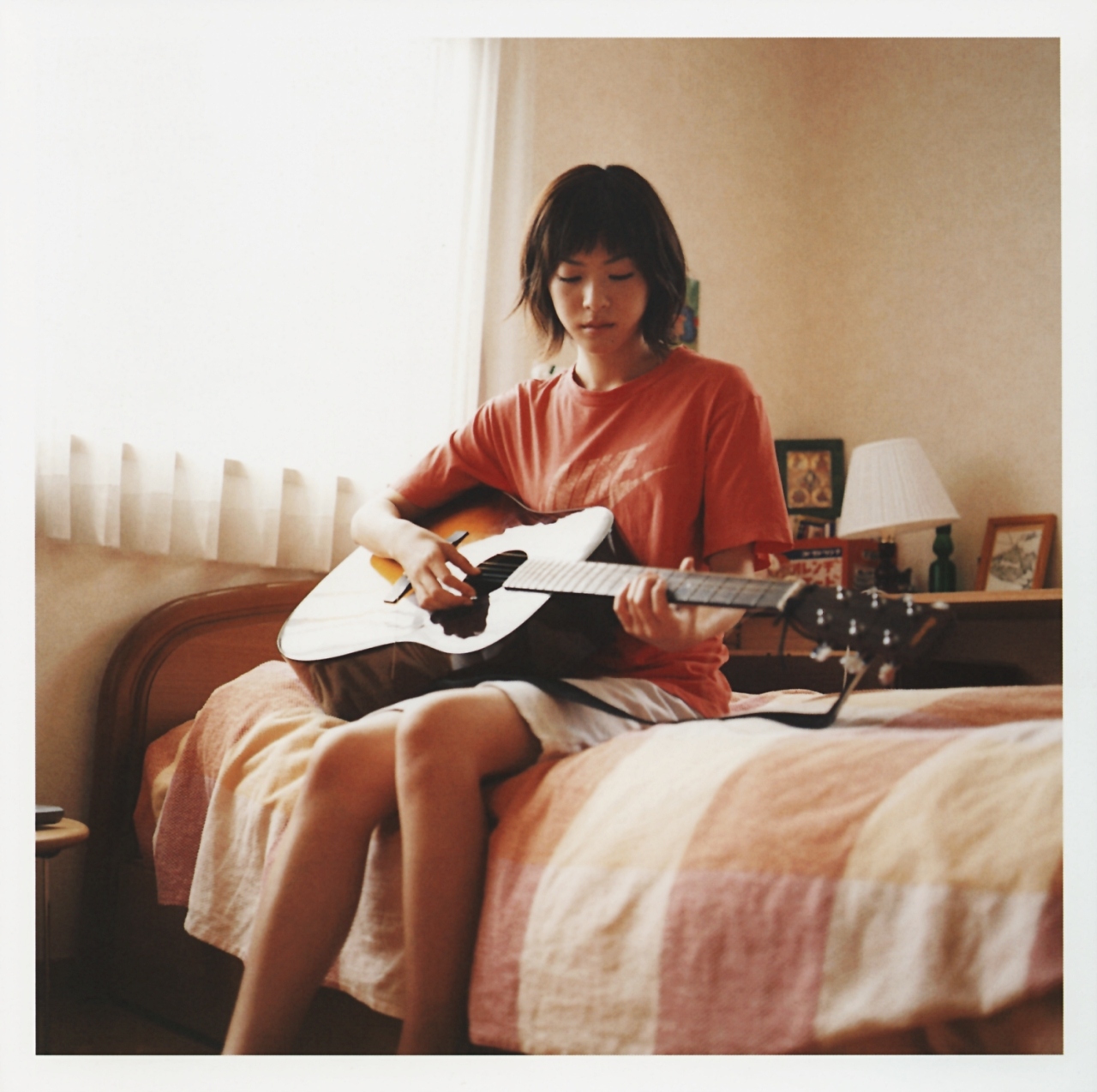 ueno juri, a piacere, highres, photo (medium), 1girl, acoustic guitar, bed, female focus, guitar, instrument, shirt, solo, t-shirt