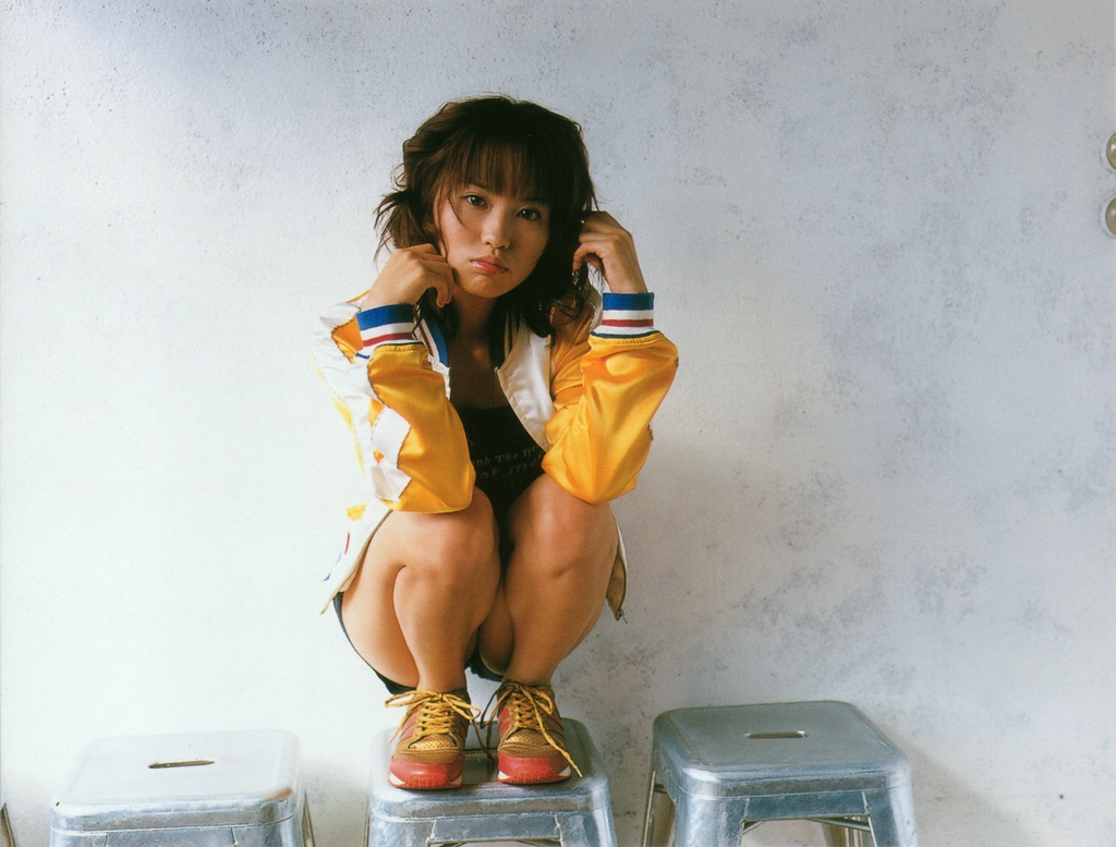 ichikawa yui, photo (medium), 1girl, asian, denim, female focus, halterneck, indoors, jacket, looking at viewer, shorts, solo, squatting, stool