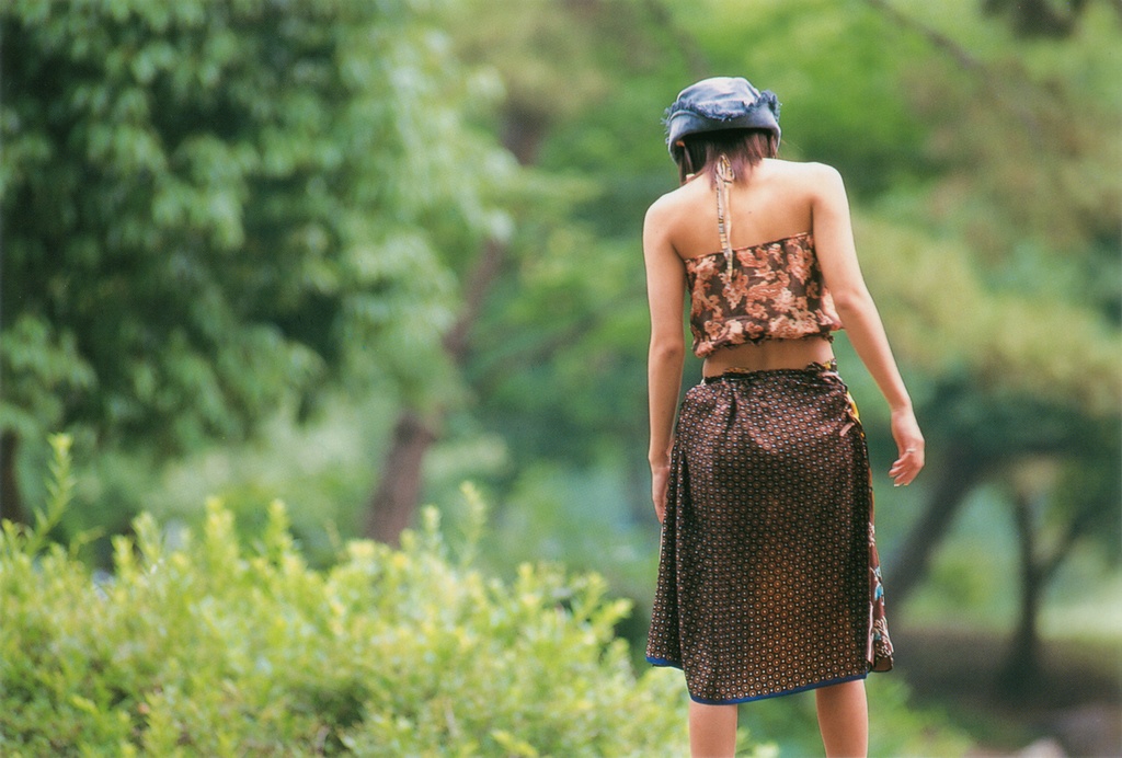 ichikawa yui, photo (medium), 1girl, asian, brown hair, female focus, from behind, halterneck, hat, midriff, outdoors, skirt, solo, tree