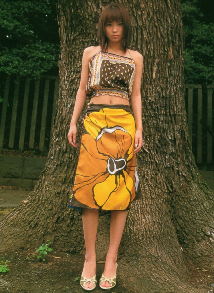 ichikawa yui, photo (medium), 1girl, asian, bare legs, bare shoulders, brown hair, female focus, halterneck, looking at viewer, midriff, outdoors, shoes, skirt, solo, standing, tree