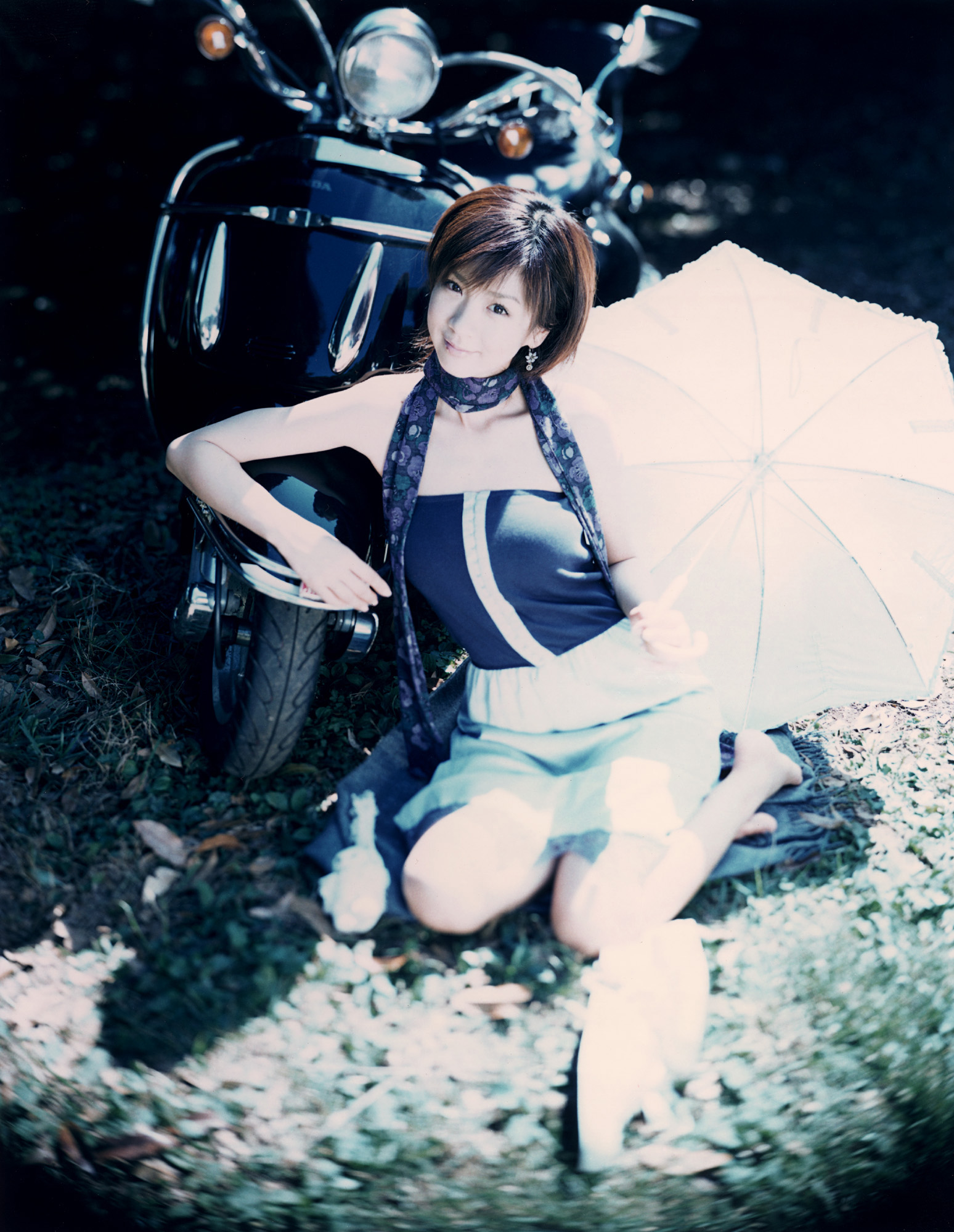 hoshino aki, vehicle, highres, photo (medium), 1girl, asian, dress, female focus, japanese (nationality), motor vehicle, outdoors, scarf, scooter, sitting, solo, strapless, strapless dress, umbrella, yokozuwari