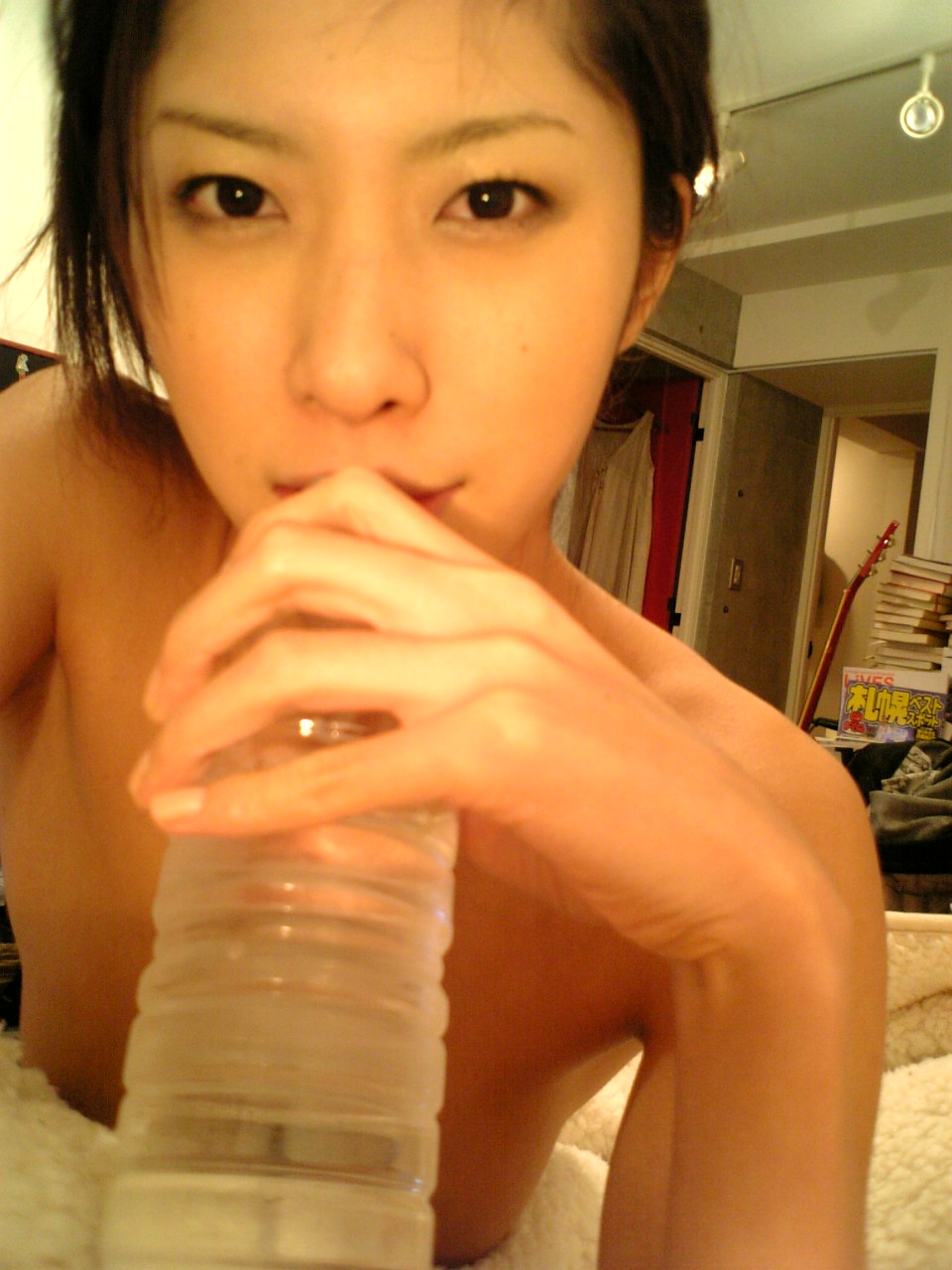 tachibana riko, highres, photo (medium), 1girl, asian, blanket, bottle, female focus, indoors, looking at viewer, no shirt, solo, water bottle