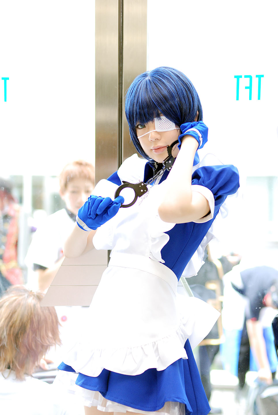 namada, ryomou shimei, ikkitousen, highres, photo (medium), 1girl, apron, asian, blue eyes, blue gloves, blue hair, collar, color contacts, cosplay, cross, cuffs, eyepatch, gloves, handcuffs, looking at viewer, maid, maid apron, puffy short sleeves, puffy sleeves, ryomou shimei (cosplay), short sleeves, solo focus, standing