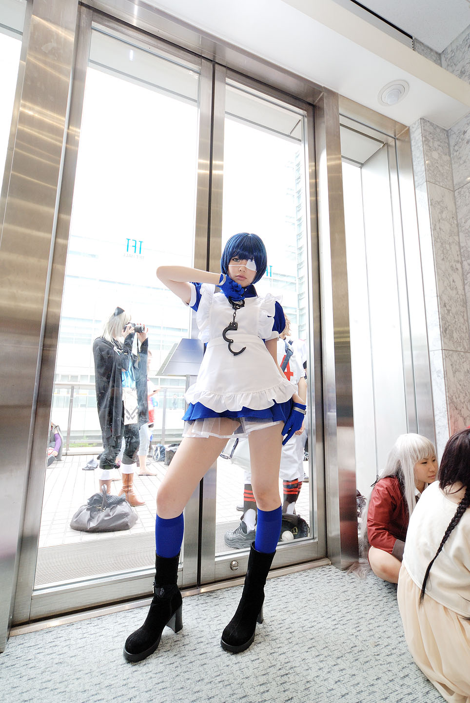 namada, ryomou shimei, ikkitousen, black footwear, highres, photo (medium), 1girl, 4girls, apron, asian, blue eyes, blue gloves, blue hair, blue socks, boots, collar, color contacts, contrapposto, cosplay, cross, cuffs, eyepatch, full body, gloves, handcuffs, high heels, indoors, kneehighs, looking at viewer, maid, maid apron, multiple girls, puffy short sleeves, puffy sleeves, ryomou shimei (cosplay), short sleeves, socks, solo focus, standing