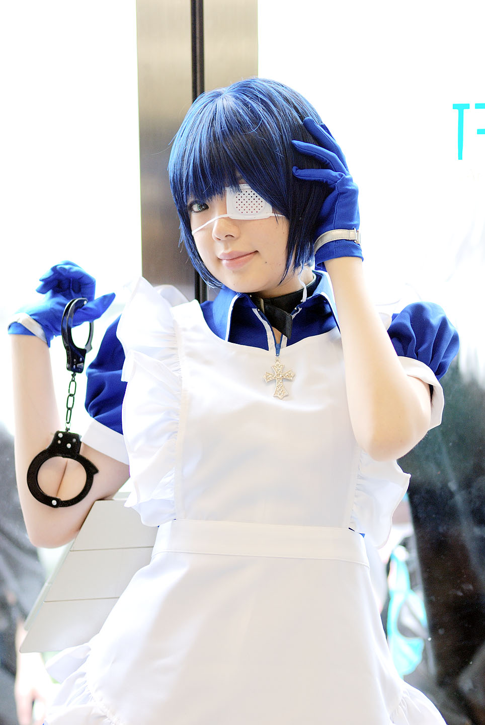 namada, ryomou shimei, ikkitousen, highres, photo (medium), 1girl, apron, asian, blue eyes, blue gloves, blue hair, collar, color contacts, cosplay, cross, cuffs, eyepatch, female focus, gloves, handcuffs, looking at viewer, maid, maid apron, puffy short sleeves, puffy sleeves, ryomou shimei (cosplay), short sleeves, solo, standing