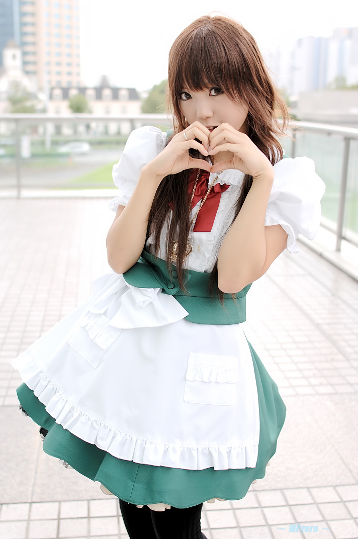 kipi-san, real life, cosplay photo, photo (medium), 1girl, apron, asian, black pantyhose, blurry, bow, brown eyes, brown hair, cosplay, depth of field, female focus, frills, heart, heart hands, jewelry, long hair, looking at viewer, maid, maid apron, outdoors, pantyhose, ring, solo, standing, waist apron, waitress