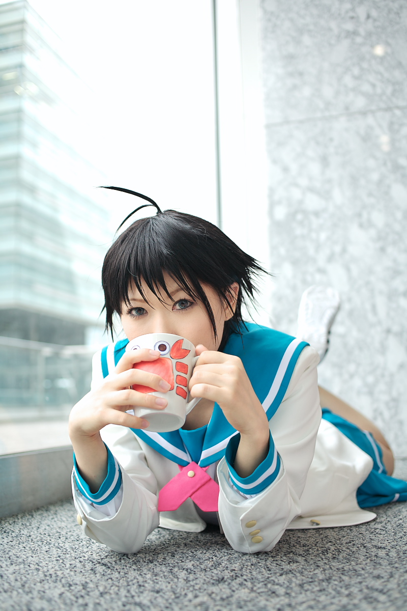 chippi, kikuchi makoto, idolmaster, idolmaster xenoglossia, highres, photo (medium), 1girl, ahoge, asian, blue eyes, coffee mug, color contacts, cosplay, cup, female focus, indoors, kikuchi makoto (cosplay), looking at viewer, lying, mug, on stomach, school uniform, serafuku, short hair, solo