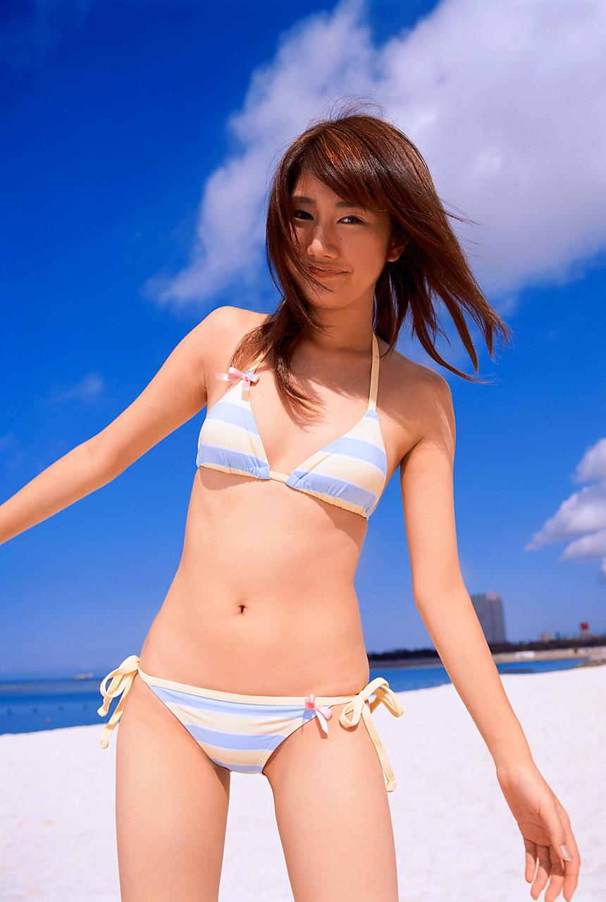 takigawa hanako, highres, photo (medium), 1girl, asian, beach, bikini, blurry, breasts, cloud, cowboy shot, depth of field, female focus, japanese (nationality), long hair, looking at viewer, ocean, outdoors, side-tie bikini bottom, sky, small breasts, smile, solo, standing, striped bikini, striped clothes, swimsuit