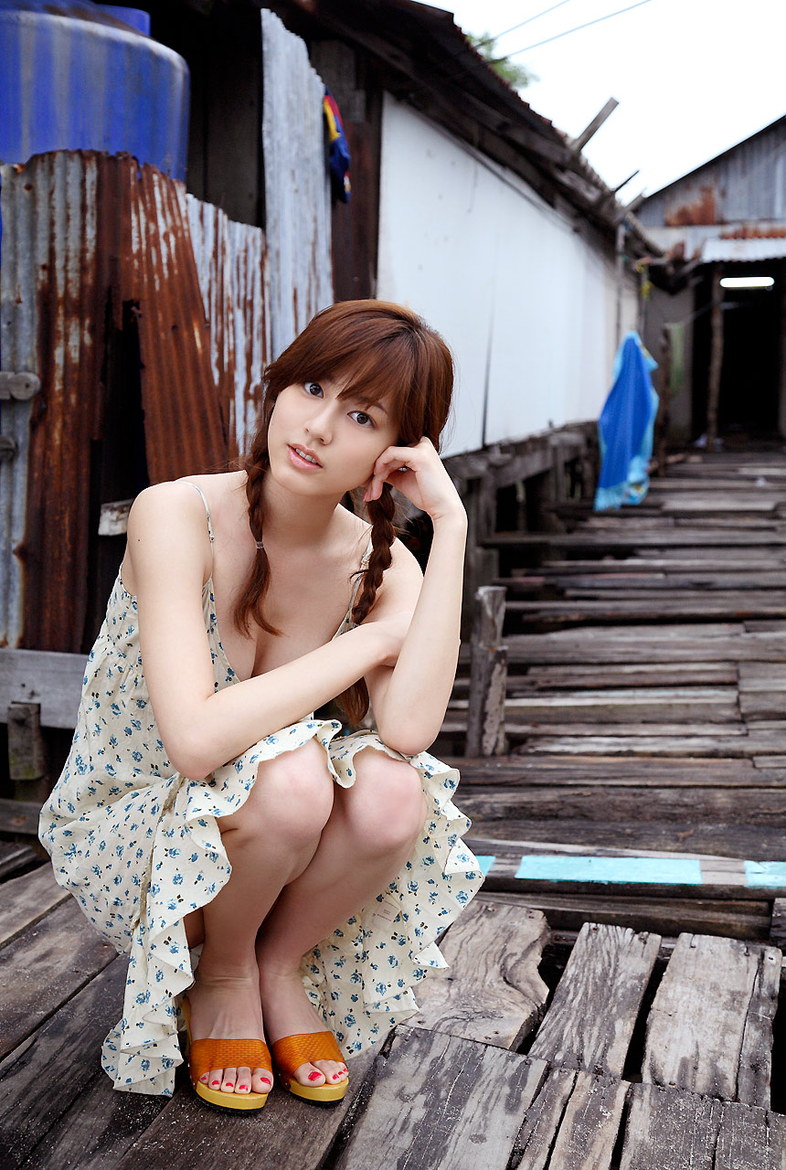 sugimoto yumi, rosebud, highres, photo (medium), 1girl, asian, braid, brown hair, dress, female focus, long hair, looking at viewer, nail polish, outdoors, solo, squatting, sundress, toenail polish, toenails, twin braids
