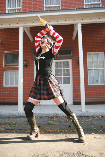 omi gibson, frederica sawyer, black lagoon, striped, photo (medium), 1girl, asian, boots, chainsaw, cosplay, female focus, frederica sawyer (cosplay), lace-up boots, plaid clothes, plaid skirt, pleated skirt, punk, skirt, thighhighs