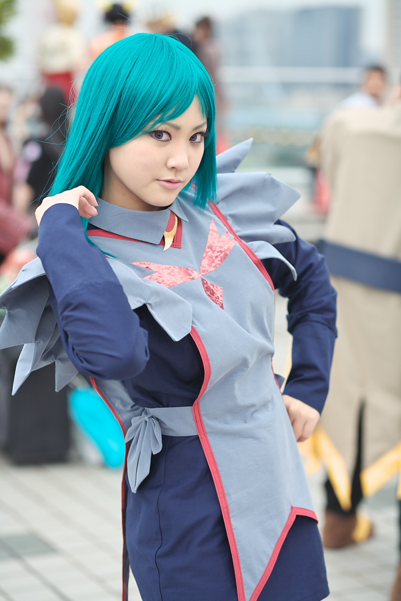 yurika (cosplayer), tomoe marguerite, my-otome, highres, photo (medium), 1girl, apron, aqua hair, asian, blue hair, blurry, cosplay, depth of field, hand on own hip, long hair, looking at viewer, maid, maid apron, outdoors, school uniform, solo focus, tomoe marguerite (cosplay)
