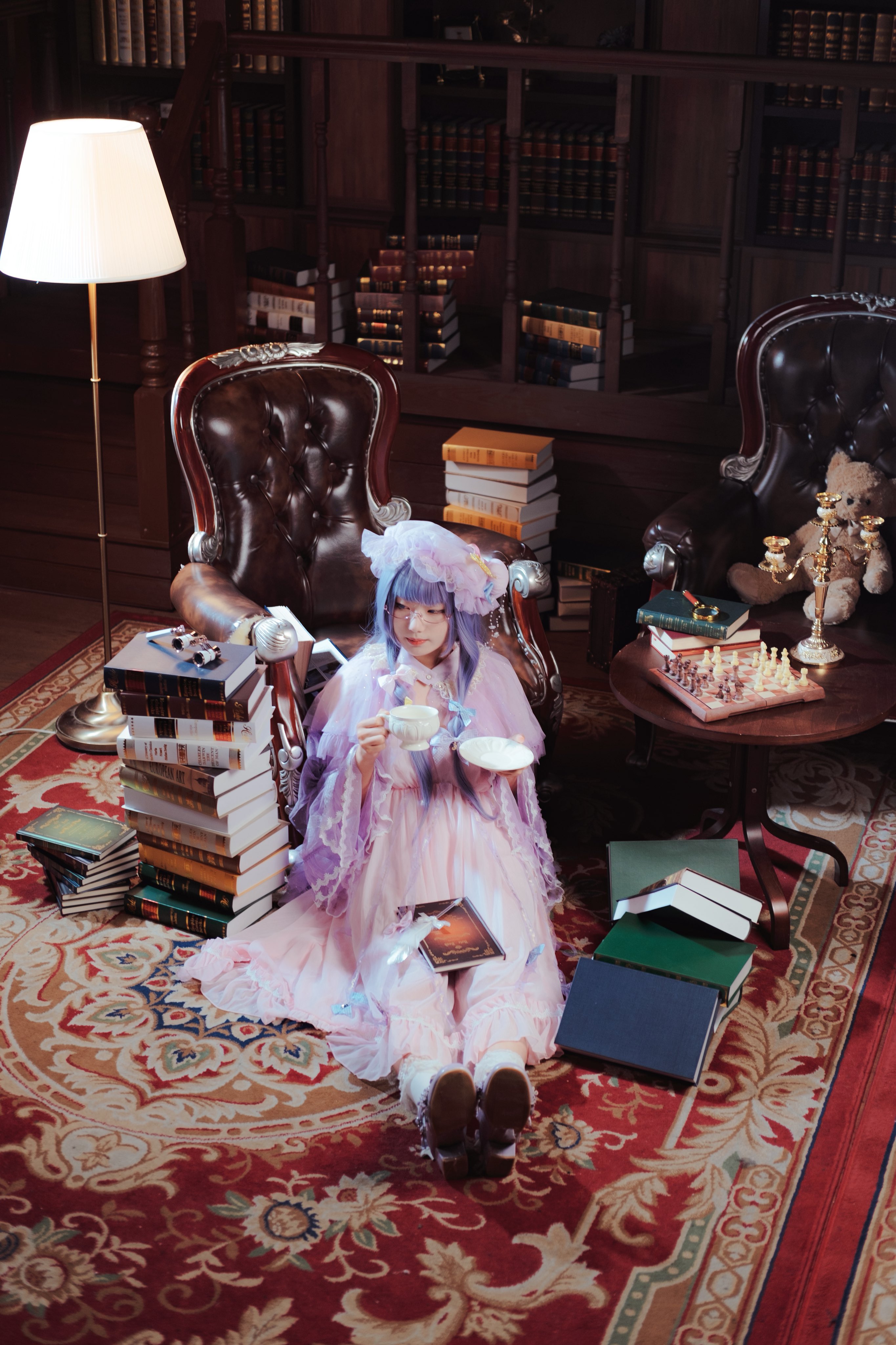 patchouli knowledge, absurdres, highres, photo (medium), 1girl, book, book stack, carpet, chess piece, chessboard, indoors, lamp, sinkai cos, sitting