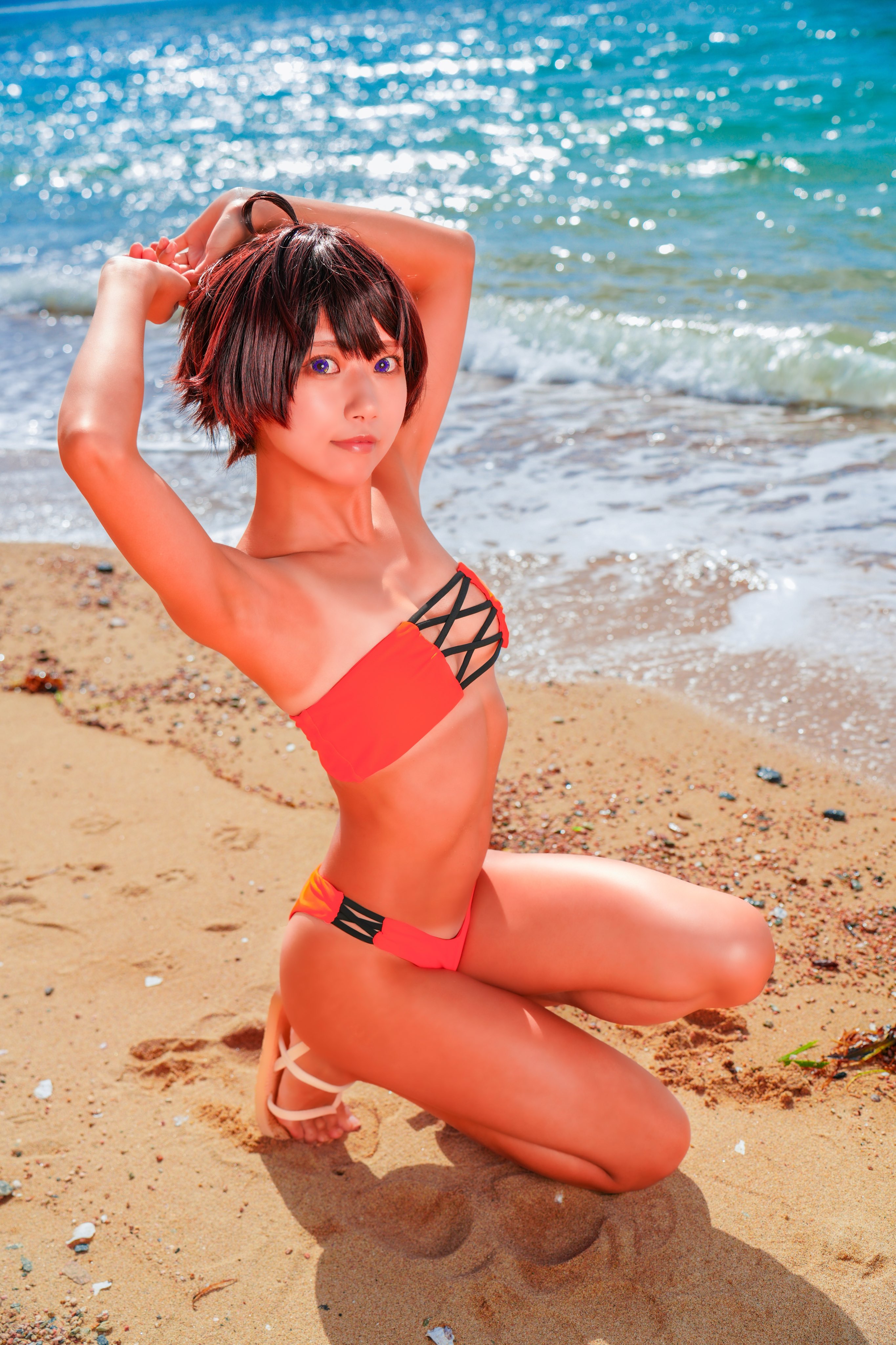 negoto hitsuji, yakishio lemon, make heroine ga oo sugiru!, real life, absurdres, commentary, cosplay photo, highres, photo (medium), 1girl, 2025, ahoge, armpits, arms up, ass, bikini, black hair, blue sky, blurry, breasts, closed mouth, collarbone, cosplay, dark-skinned female, dark skin, depth of field, dutch angle, feet, female focus, food-themed hair ornament, full body, groin, hair between eyes, hair ornament, kneeling, looking at viewer, medium breasts, mountainous horizon, navel, ocean, orange bikini, outdoors, purple eyes, red lips, round teeth, sand, sandals, shadow, shore, short hair, sky, smile, solo, squatting, strapless, strapless bikini, swimsuit, tan, tanline, teeth, thigh gap, thighs, toes, upper teeth only, waves, yakishio lemon (cosplay)
