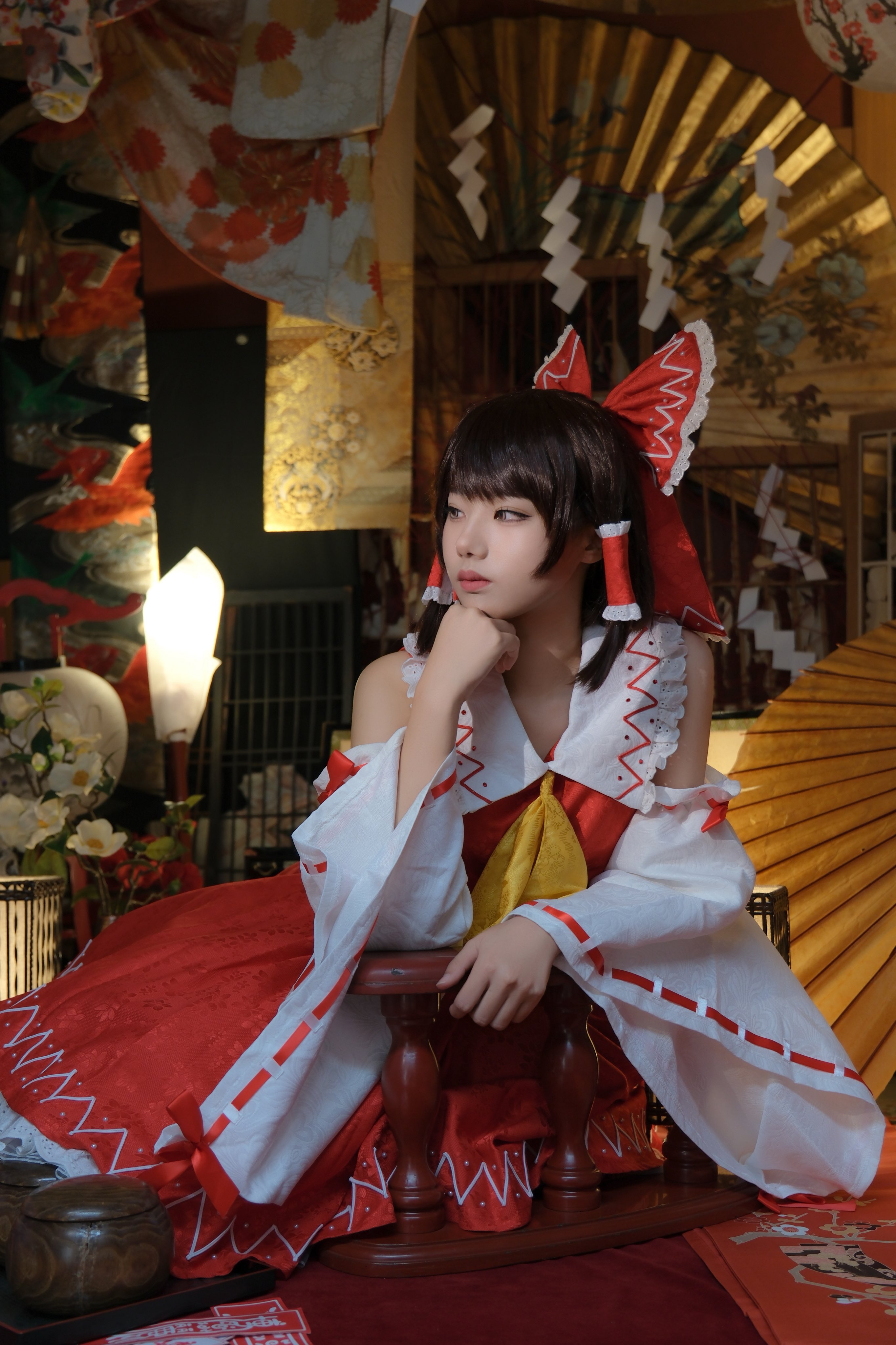 hakurei reimu, touhou, absurdres, cosplay photo, highres, photo (medium), 1girl, ascot, brown eyes, brown hair, clenched hand, cosplay, detached sleeves, folding fan, hand fan, looking at viewer, sinkai cos, solo, wide sleeves, yellow ascot