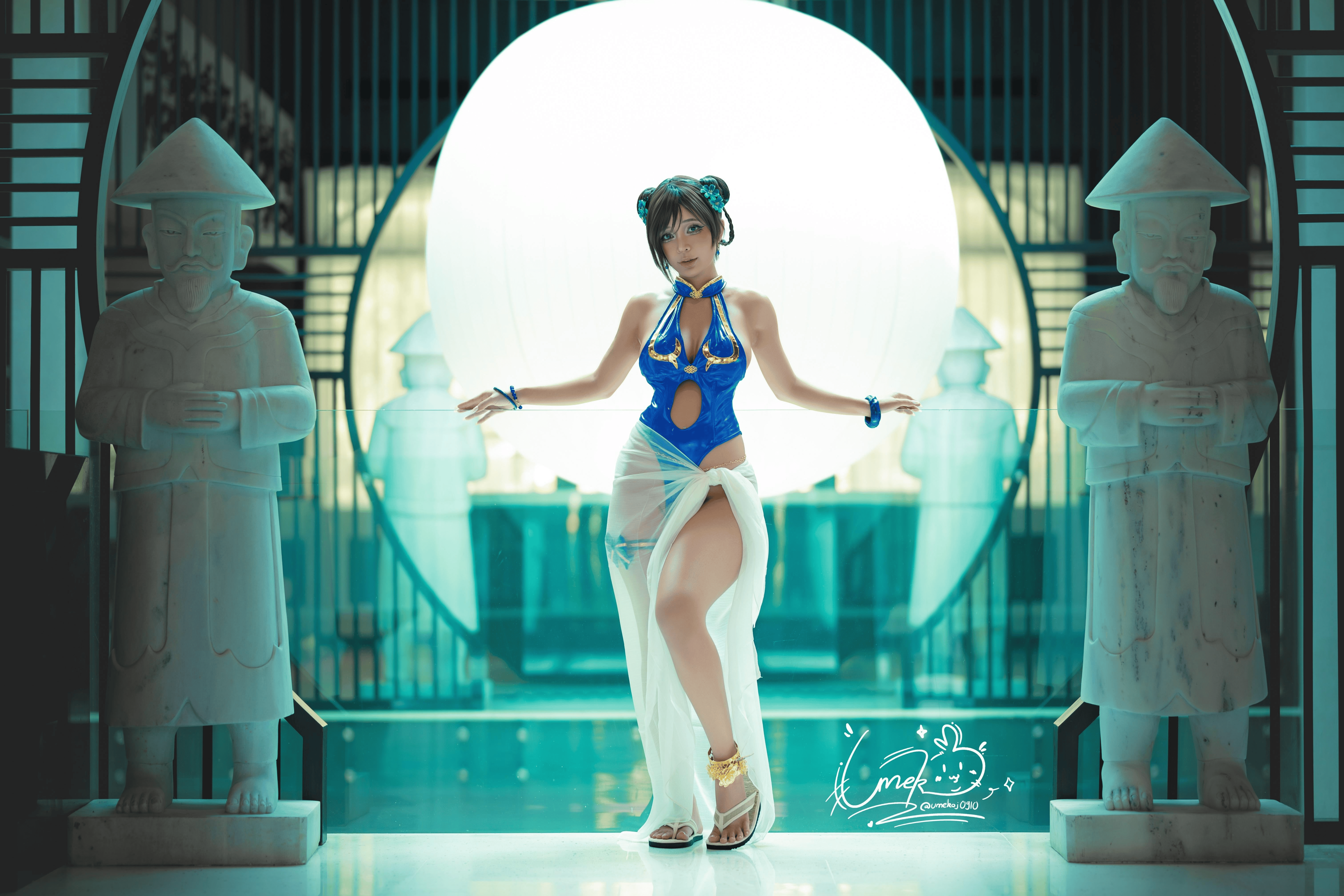 umeko j, umekojcosplayer, chun-li, capcom, real life, street fighter, street fighter 6, absurdres, cosplay photo, highres, photo (medium), 1girl, artist name, blue one-piece swimsuit, chun-li (cosplay), cosplay, female focus, flower, hair flower, hair ornament, official alternate costume, one-piece swimsuit, sarong, swimsuit, vietnamese