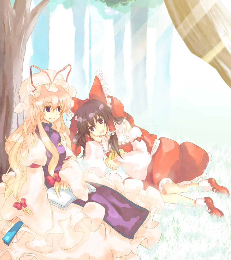 akarino, akarino (yucco), hakurei reimu, yakumo yukari, touhou, 2girls, against tree, blonde hair, book, female focus, folded fan, folding fan, forest, grass, hand fan, hat, japanese clothes, light rays, long hair, lying, miko, multiple girls, nature, on side, ribbon, sitting, sunbeam, sunlight, tree