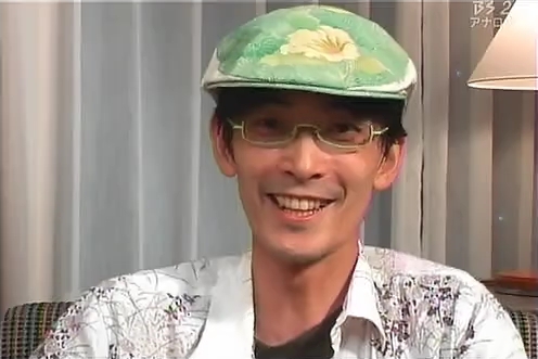 zun, real life, touhou, screencap, lowres, photo (medium), 1boy, asian, black hair, glasses, hat, male focus, smile, solo, zun hat