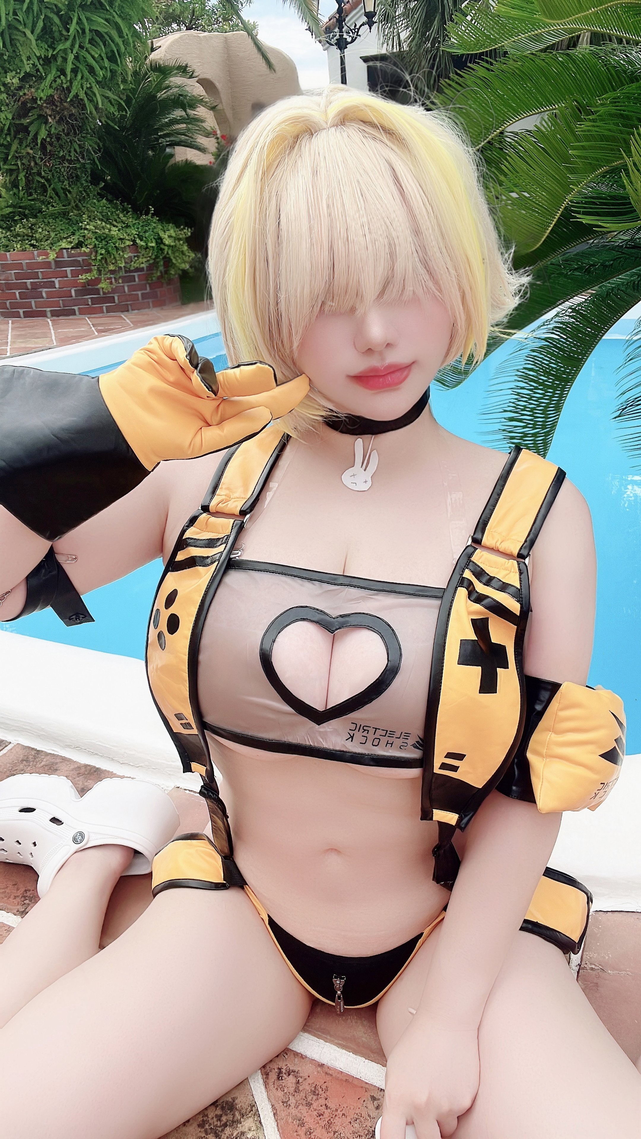 saku93, elegg (nikke), goddess of victory: nikke, real life, photo (medium), 1girl, animal print, blonde hair, breasts, choker, cleavage, clothing cutout, cosplay, crocs, floaty, gloves, hair between eyes, heart cutout, japanese (nationality), navel, outdoors, pool, poolside, rabbit print, short hair, solo, solo focus, swimsuit, tree