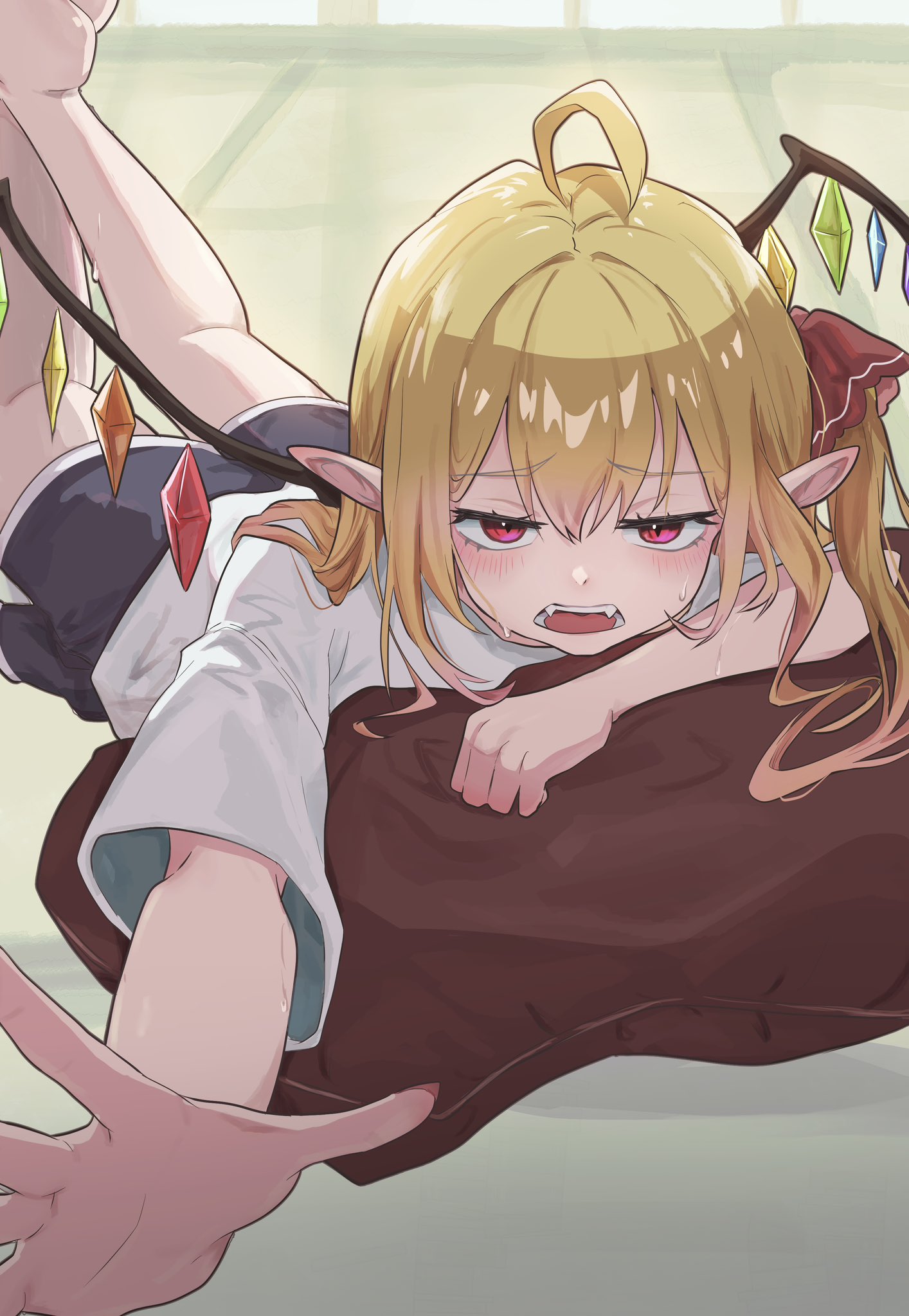 delta delta, flandre scarlet, touhou, commentary, highres, 1girl, ahoge, black shorts, blonde hair, crystal wings, embarrassed, fangs, jitome, long hair, lying, on pillow, on stomach, open mouth, pointy ears, reaching, reaching towards viewer, red eyes, shirt, shorts, solo, vampire, white shirt, wings