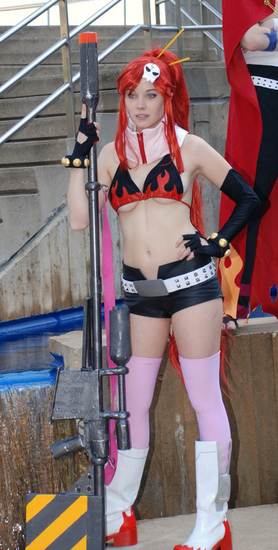 ellarcy, kamina (ttgl), yoko littner, tengen toppa gurren lagann, cosplay photo, photo (medium), 1boy, 1girl, belt, bikini, bikini top only, boots, breasts, cleavage, cosplay, elbow gloves, fingerless gloves, gloves, gun, hand on own hip, long hair, ponytail, red hair, short shorts, shorts, skull, studded belt, swimsuit, thighhighs, weapon