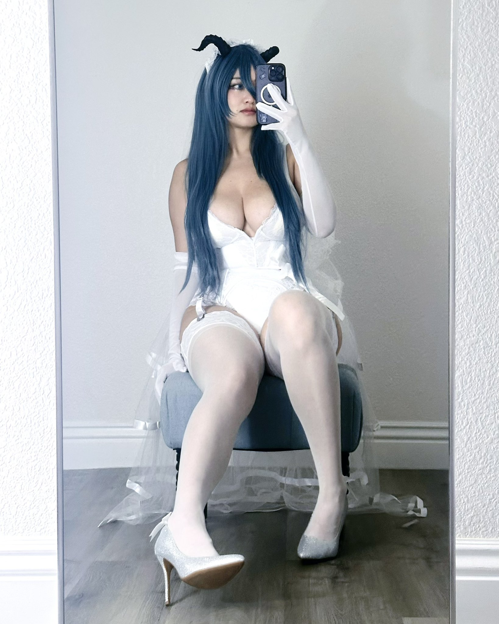 ammeerrss, echocalypse, 1girl, asian, blue eyes, blue hair, breasts, bridal veil, bride, bustier, cleavage, cosplay, garter belt, garter straps, gloves, high heels, horns, lingerie, long hair, mirror selfie, panties, phone, rosabelle (echocalypse), selfie, sitting, thighhighs, underwear, veil, white panties