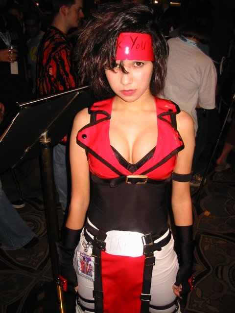 sol badgal, sol badguy, arc system works, guilty gear, cosplay photo, gender request, photo (medium), 1girl, breasts, brown hair, cleavage, cosplay, genderswap, gloves, large breasts, pants, shirt, sleeveless, sleeveless shirt, sol badguy (cosplay), white pants