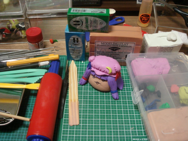 nendoroaki, alice margatroid, hakurei reimu, kirisame marisa, patchouli knowledge, touhou, photo (medium), unconventional media, box, brown eyes, clay, crescent, crescent pin, disembodied head, female focus, figure (medium), hair tie, hat, long hair, mob cap, no humans, open mouth, pink hat, scissors, smiley face, yukkuri shiteitte ne