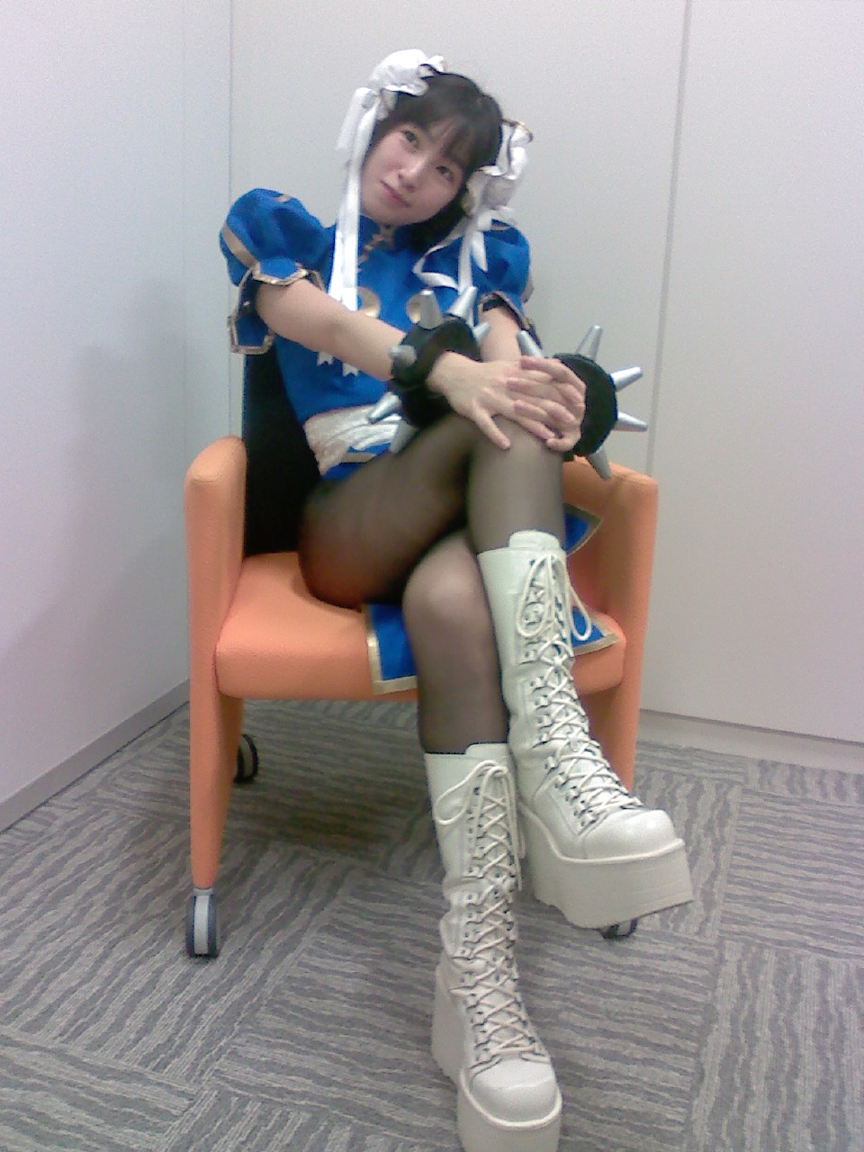 chun-li, capcom, street fighter, cosplay photo, highres, non-web source, photo (medium), 1girl, boots, bun cover, chun-li (cosplay), cosplay, crossed legs, double bun, female focus, hair bun, pantyhose, sitting, solo
