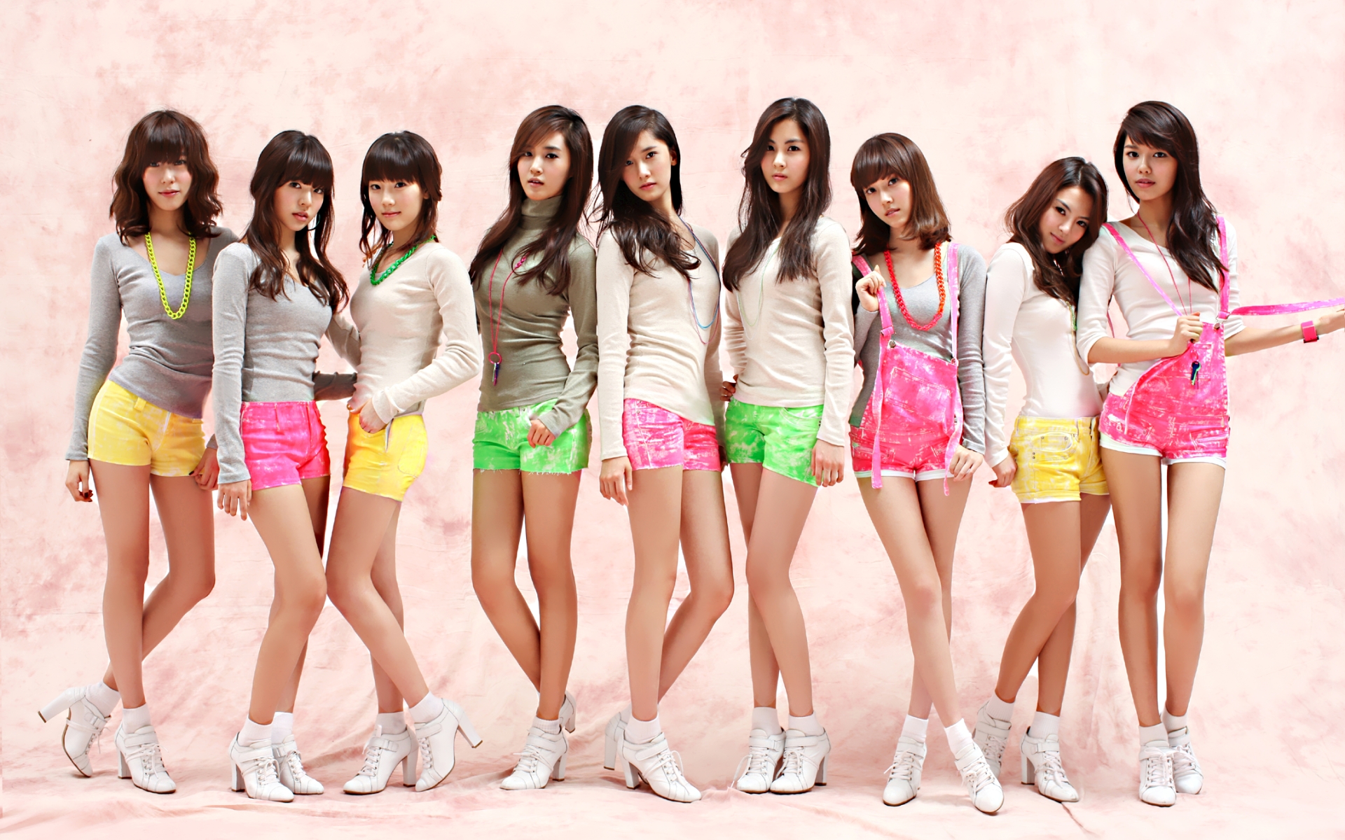hyoyeon (girls' generation), jessica (girls' generation), seohyun (girls' generation), sooyoung (girls' generation), sunny (girls' generation), taeyeon (girls' generation), tiffany (girls' generation), yoona (girls' generation), yuri (girls' generation), girls' generation, white footwear, highres, photo (medium), 6+girls, asian, bracelet, breasts, brown hair, female focus, grey shirt, high heels, jewelry, k-pop, korea, korean text, legs, long hair, long sleeves, looking at viewer, multiple girls, necklace, overalls, shirt, shoes, short hair, short shorts, shorts, standing, turtleneck, white shirt