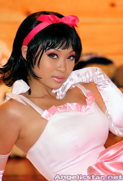 yaya han, kirigoe mima, perfect blue, photo (medium), 1girl, angelicstar, black hair, bow, cosplay, dress, female focus, gloves, indoors, photo shoot, pink bow, pink dress, short hair, sitting, solo, white dress, white gloves