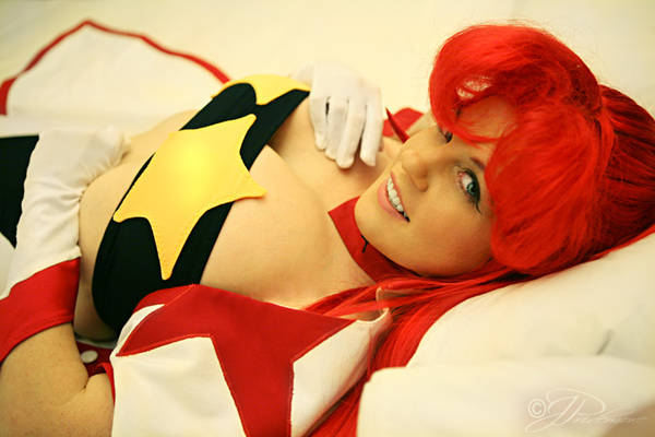 space yoko, yoko littner, tengen toppa gurren lagann, cosplay photo, photo (medium), 1girl, blue eyes, breasts, cape, cleavage, cosplay, female focus, gloves, large breasts, long hair, lying, on back, ponytail, red hair, smile, solo, strapless, tube top