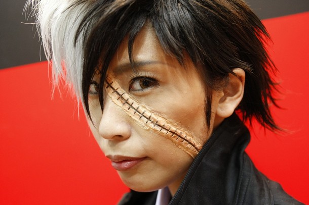 black jack, black jack (series), photo (medium), asian, black hair, cosplay, looking at viewer, makeup, multicolored hair, scar, short hair, solo, stitches, tuxedo, two-tone hair, white hair